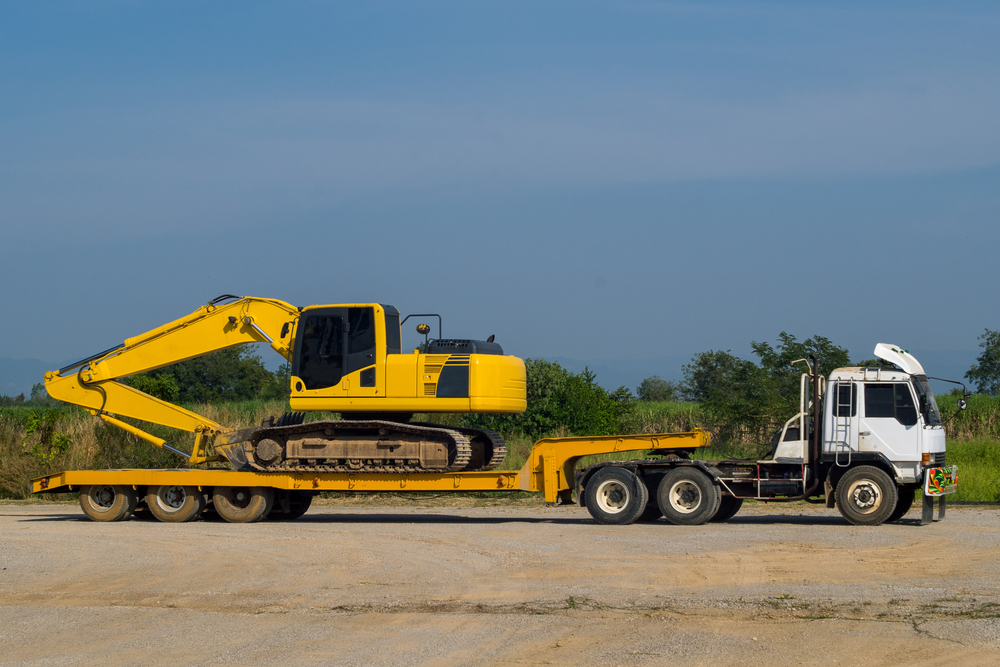 Excavator,Or,Backhoe,On,The,Truck,Hauls,Stopping,In,Site